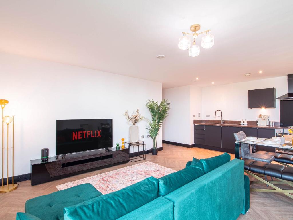 a living room with a blue couch and a tv at Stylish 2BR City-Centre Apart Near LGI & Leeds Uni Sleeps 6 in Leeds