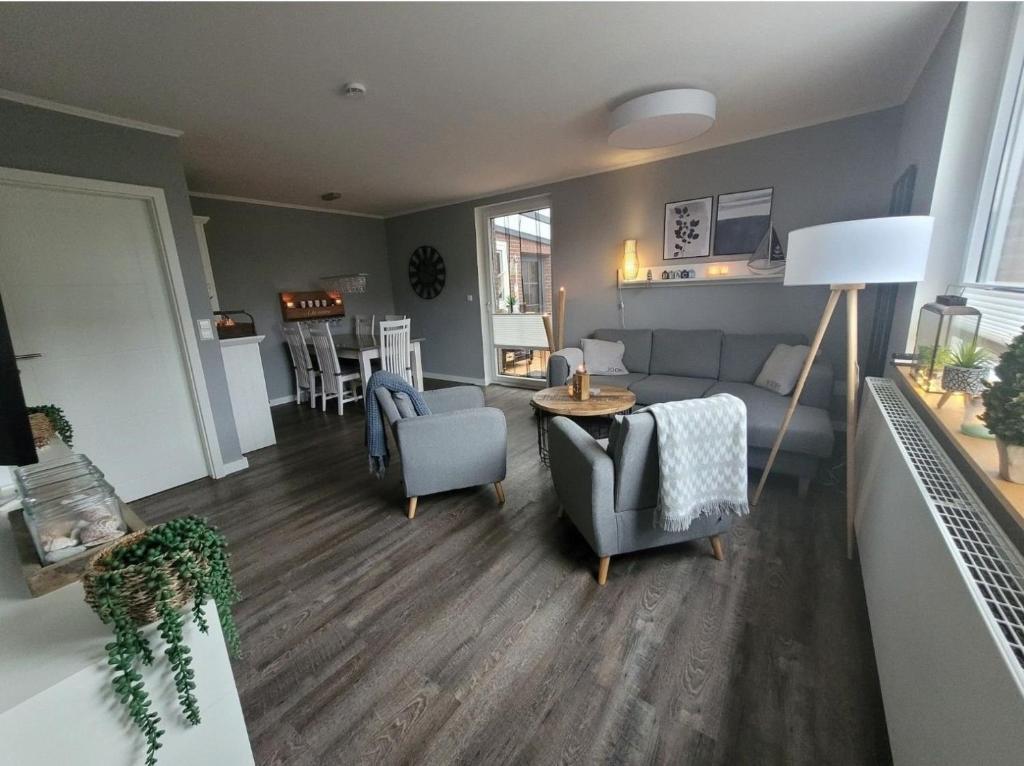 ein Wohnzimmer mit Sofa, Stühlen und einem Tisch in der Unterkunft Ferienhaus Düne 16 in Berumbur