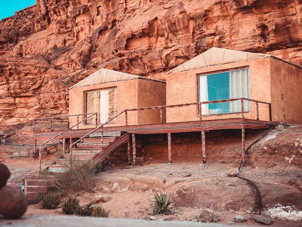 ワディ・ラムにあるMartian Desert Campの崖の上にある家とその上に建物が建っている