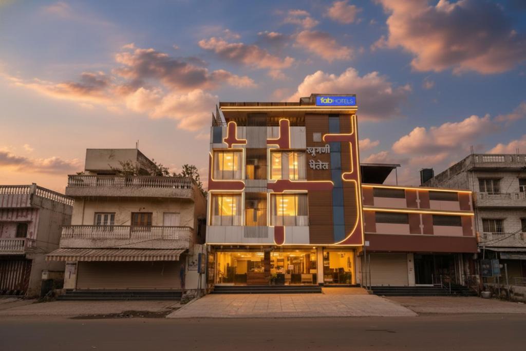 a building with a sign on the side of it at FabHotel Raghumani Palace in Ujjain