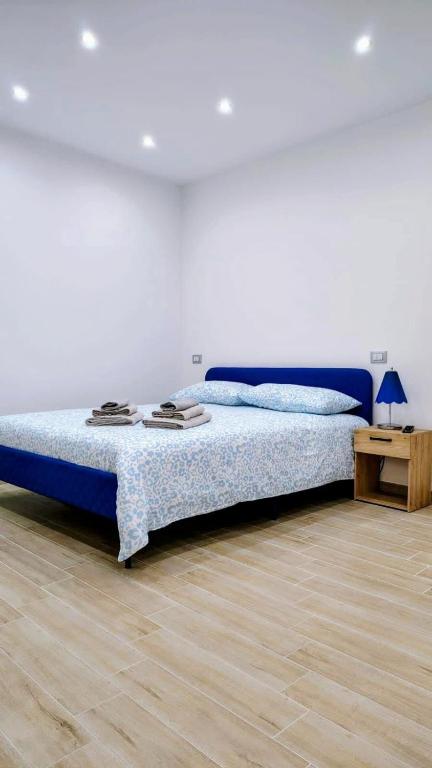 a bedroom with a bed with blue sheets and a table at Roca House in Valenzano