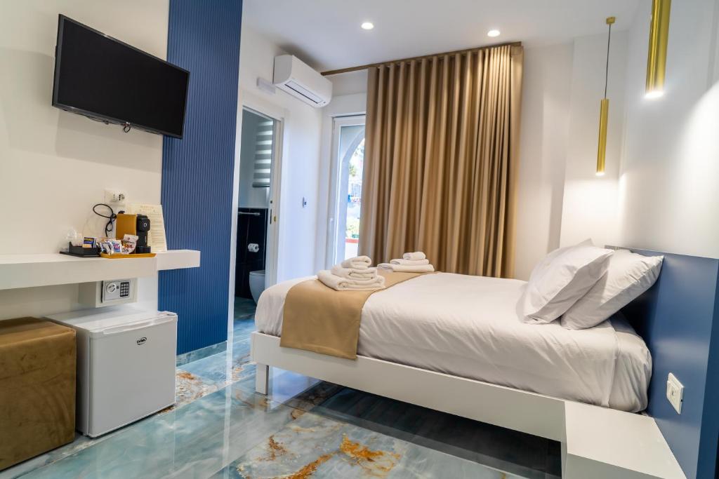Un dormitorio con una cama y un televisor en una pared. en Suite 14, en Scalea