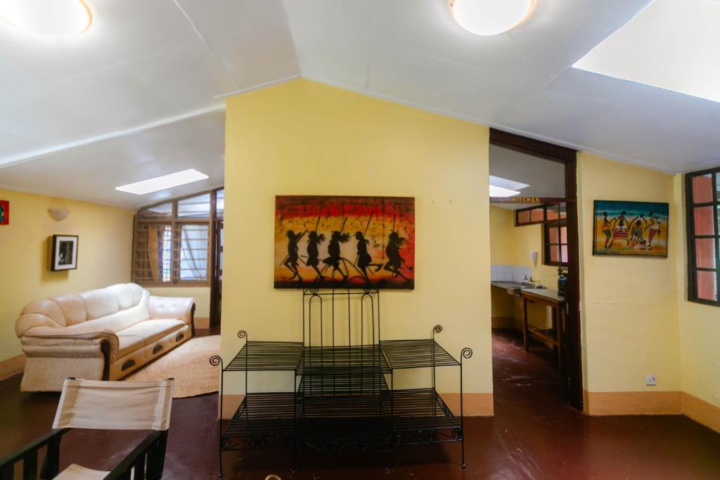 Una sala de estar con un sofá y un cuadro en la pared. en Jameson House, en Karatu