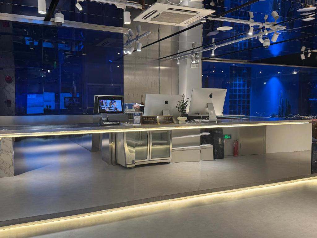un vestíbulo con un mostrador con dos ordenadores. en Third Floor Youth Hostel, en Shanghái