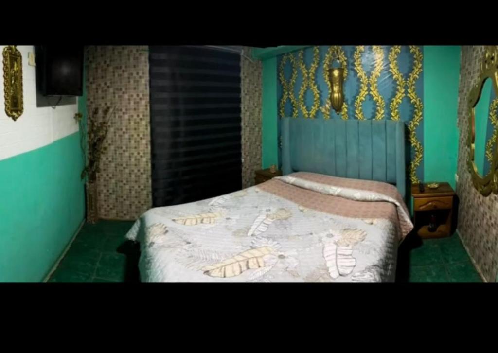 a bedroom with a bed with a gold head board at Hotel del valle San Miguel 530 in Melipilla