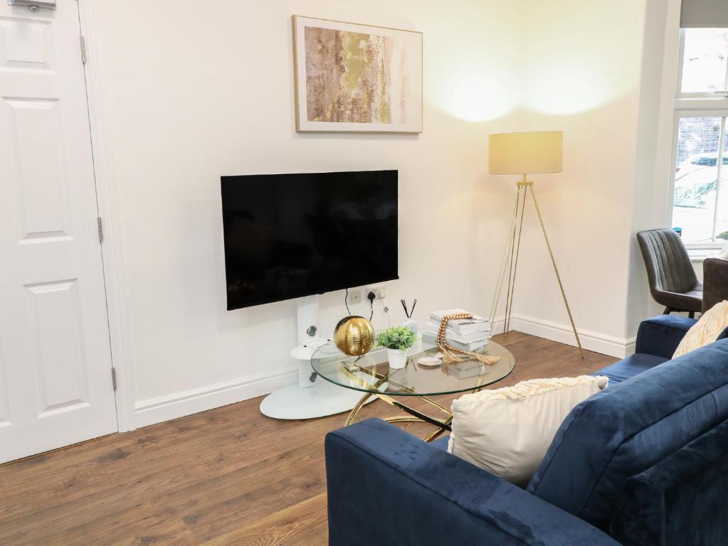 a living room with a blue couch and a tv at One in Peterborough