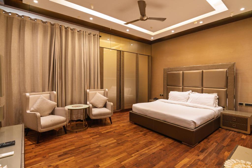 a hotel room with a bed and two chairs at Luxury HomeStay Prime Location, South Delhi in New Delhi