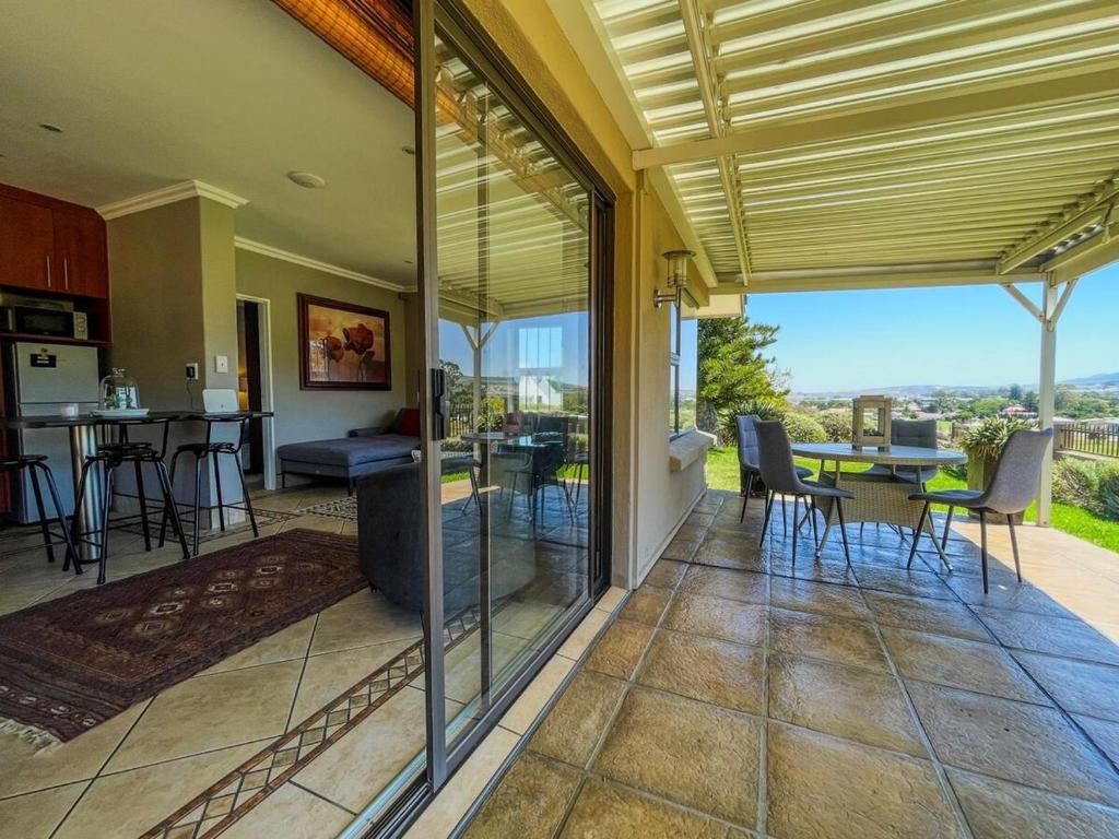an open kitchen and dining room with a view of a house at Spacious mountain-view haven in Stellenbosch