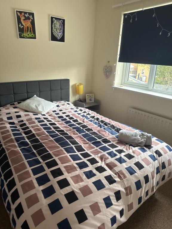 Un dormitorio con una cama con una manta a cuadros. en Double bedroom, en Peterborough