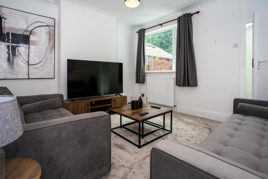 a living room with two couches and a flat screen tv at Modern 4BR Home in Dudley in Netherton