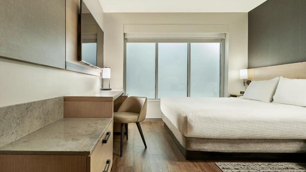 Una habitación de hotel con una cama y una ventana grande. en Hyatt Place Post Falls/Coeur D'Alene, en Post Falls