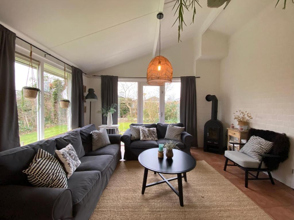 a living room with a couch and a table at Bungalow 007 in Petten