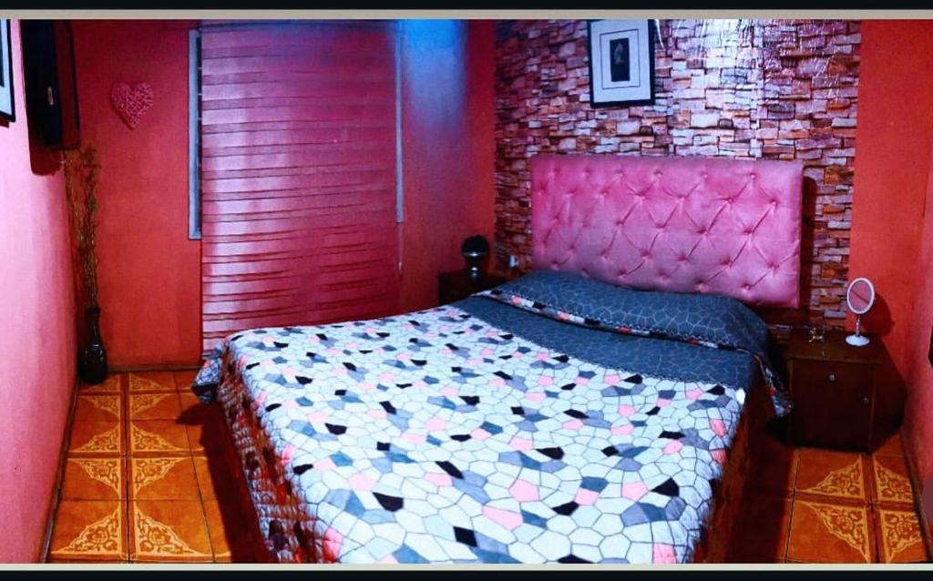 a bedroom with a bed and a brick wall at Hotel del valle in Melipilla