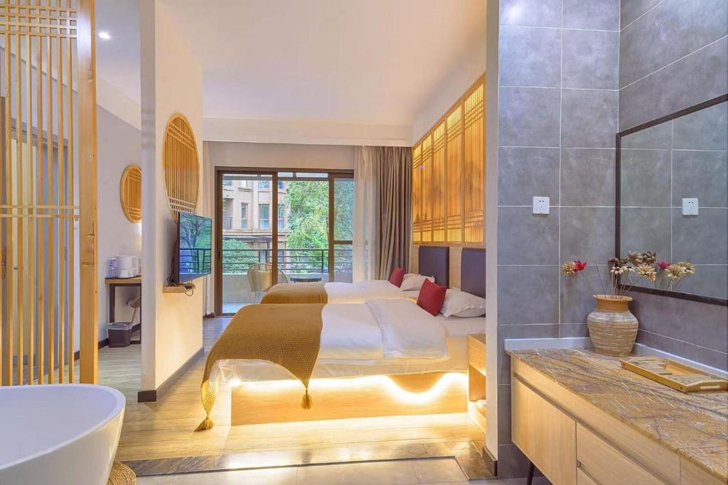 a bedroom with a bed and a tub and a sink at Heinemann Hotel Terrace Double Room A206 with Jacuzzi and local amenities in Baoguosi