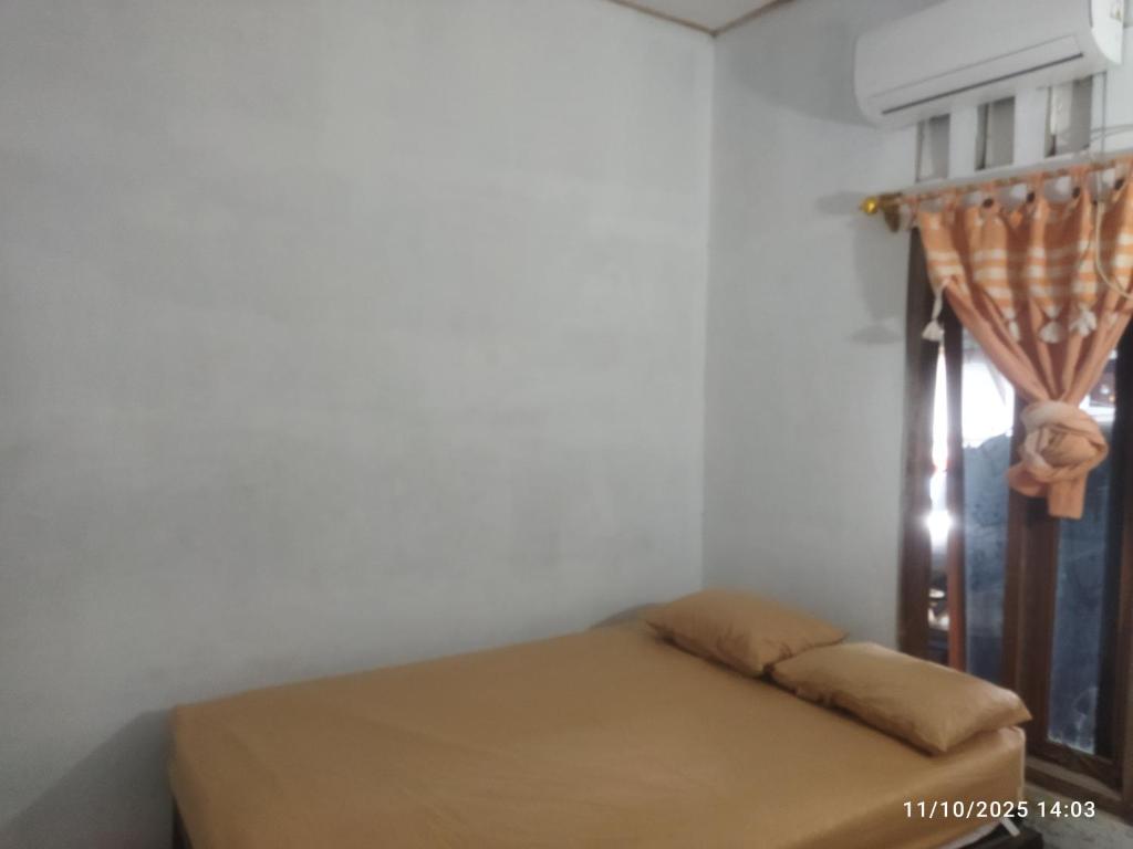 una cama en una habitación con ventana en Kasutapan homestay, en Kembangarum