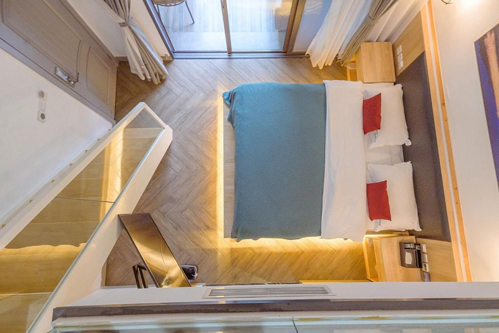a small room with a bed and a staircase at Heinemann Hotel loft suite with two king beds B306 with a jacuzzi and a local in Baoguosi