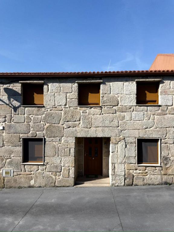 a stone building with a large doorway and a door at Casa Alicia in Carnota