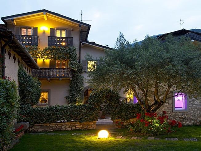 a large house with a tree in the yard at Bed and Breakfast Casa del Nonno in Adrara San Martino
