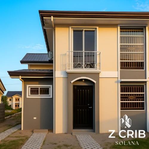 a house with a black door and a balcony at Z Crib Solana in Bacolor