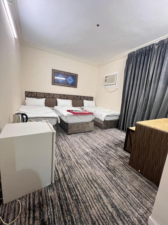 a hotel room with two beds and a couch at نزل الزائر 2 in Medina