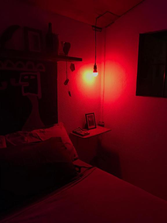 a dark room with a bed and a red light at The Art House in Villasis