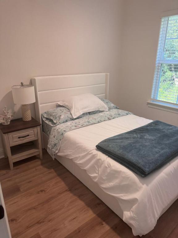 a bed with a blue blanket on it in a bedroom at Chic Beach Home Near Airport Casino Base in Gulfport