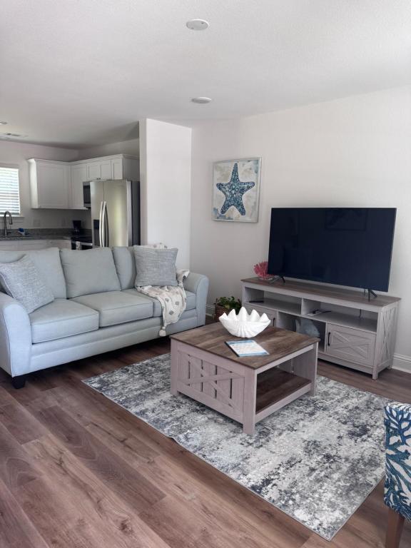 a living room with a couch and a flat screen tv at Chic Beach Home Near Airport Casino Coliseum Base in Gulfport
