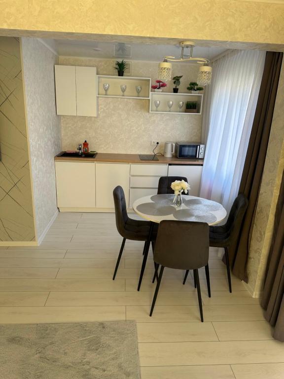 eine kleine Küche mit einem Tisch und Stühlen in der Unterkunft Квартира 1,5 Евро-люкс in Öskemen