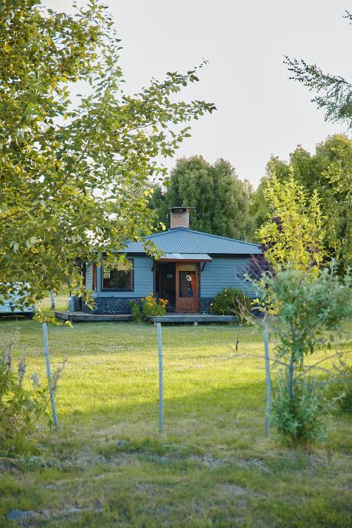 a blue house in the middle of a yard at Cabaña Cordón Situación in Trevelín