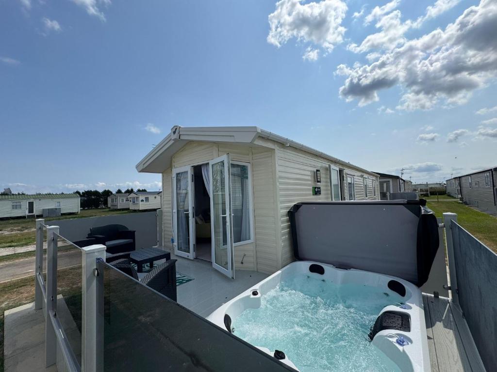 a hot tub on the balcony of a house at Fantasy Island - Eastgate E5 - The Sierra with Hot Tub - Coastal Caravan Breaks in Ingoldmells