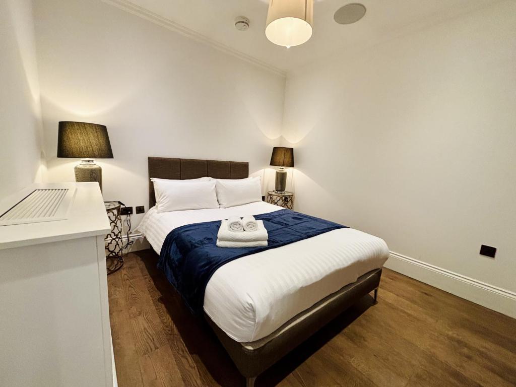 ein Schlafzimmer mit einem großen Bett mit zwei Lampen in der Unterkunft Charming 1BR City Retreat soho&covent garden in London