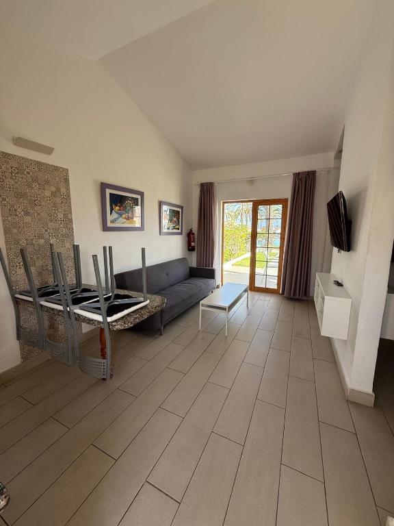 a living room with a couch and a tv at Secret Bungalow, Los Arcos in San Bartolomé