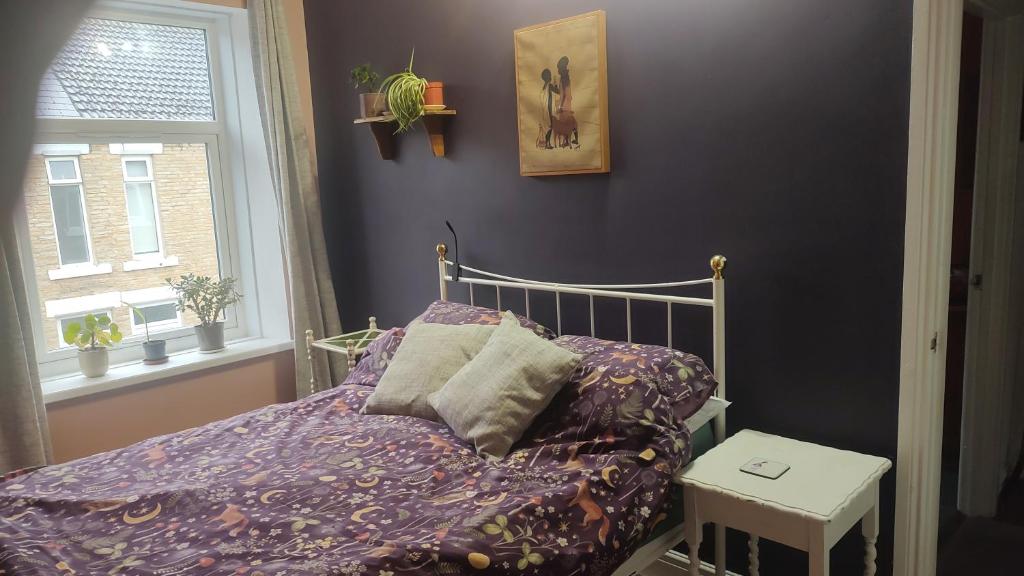 a bedroom with a bed with purple sheets and a window at Bishop bed and breakfast in Bishop Auckland