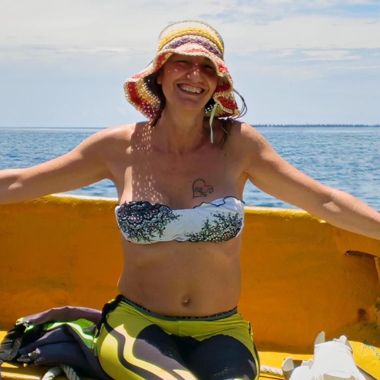 a woman in a bikini and a hat on a boat at Turtle Garden Lodge in Semporna
