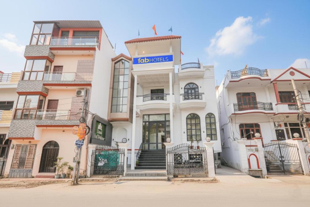 a large white building with a sign on it at FabHotel Raj Palace in Lucknow