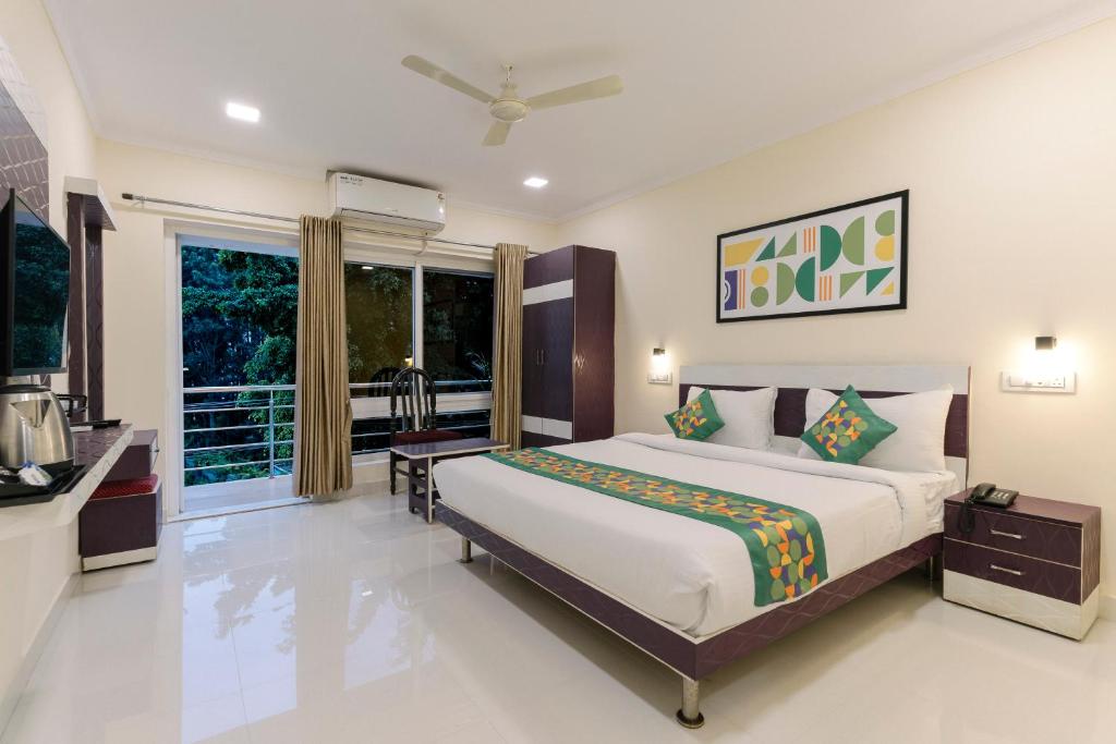 une chambre avec un grand lit et une fenêtre dans l'établissement Treebo SNS Grand Inn, à Yelagiri
