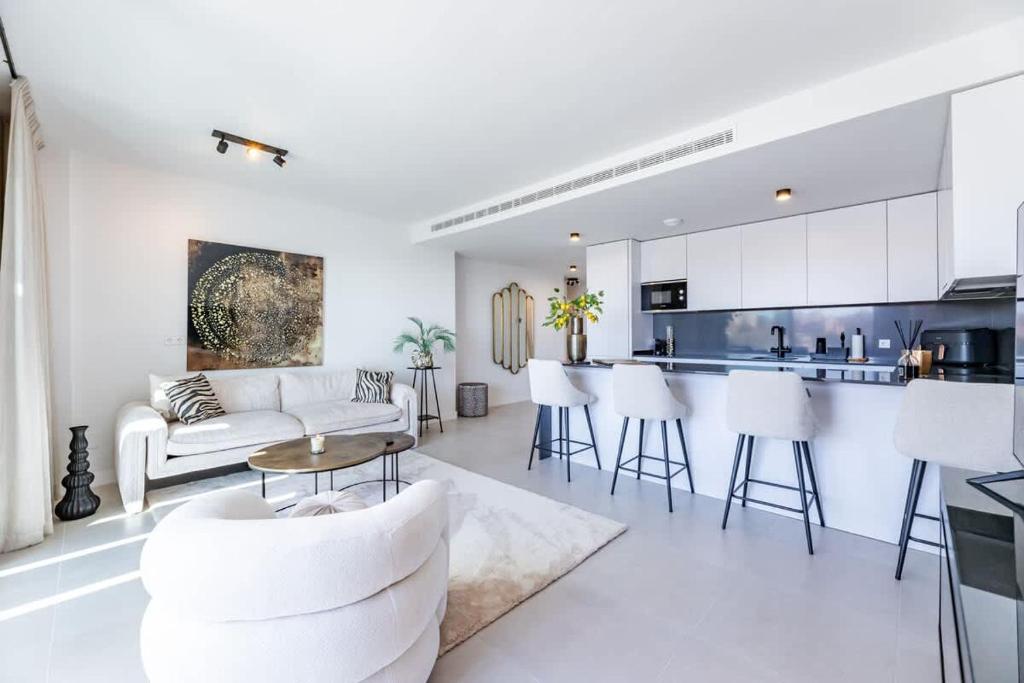 ラ・カラ・デ・ミハスにあるLuxury 2BD Flat - Pools - Parking - Spa - Gymのリビングルーム(白い家具付)、キッチン