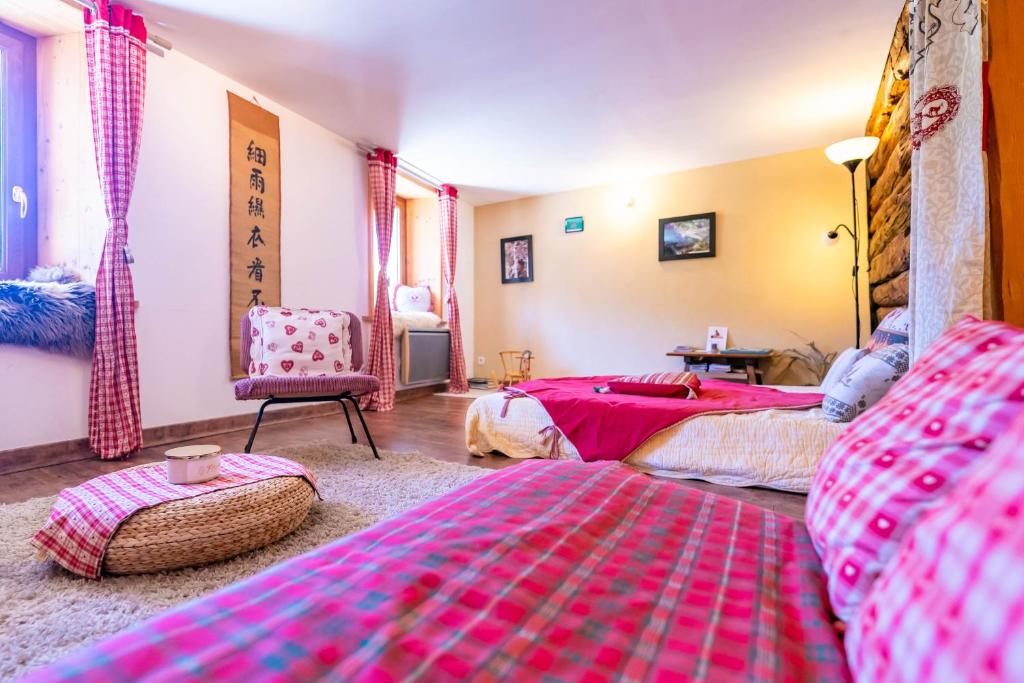 Un dormitorio con dos camas y una silla. en Bel appartement confortable et lumineux Molines en Queyras - Saint Véran, en Molines-en-Queyras