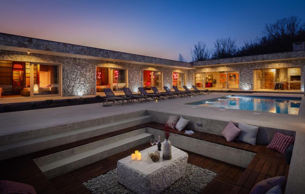 a house with a swimming pool with a table and chairs at Villa Fantazija - Split by Villas Guide in Klanac