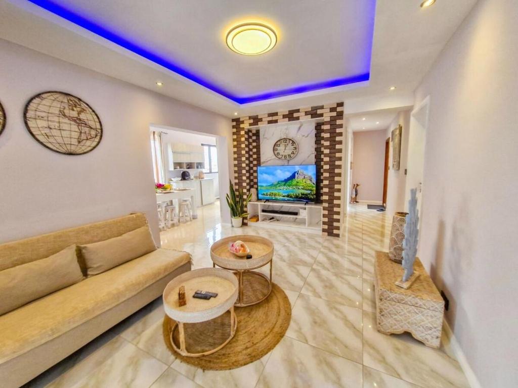 a living room with a couch and a table at Blue vibes in Flic-en-Flac