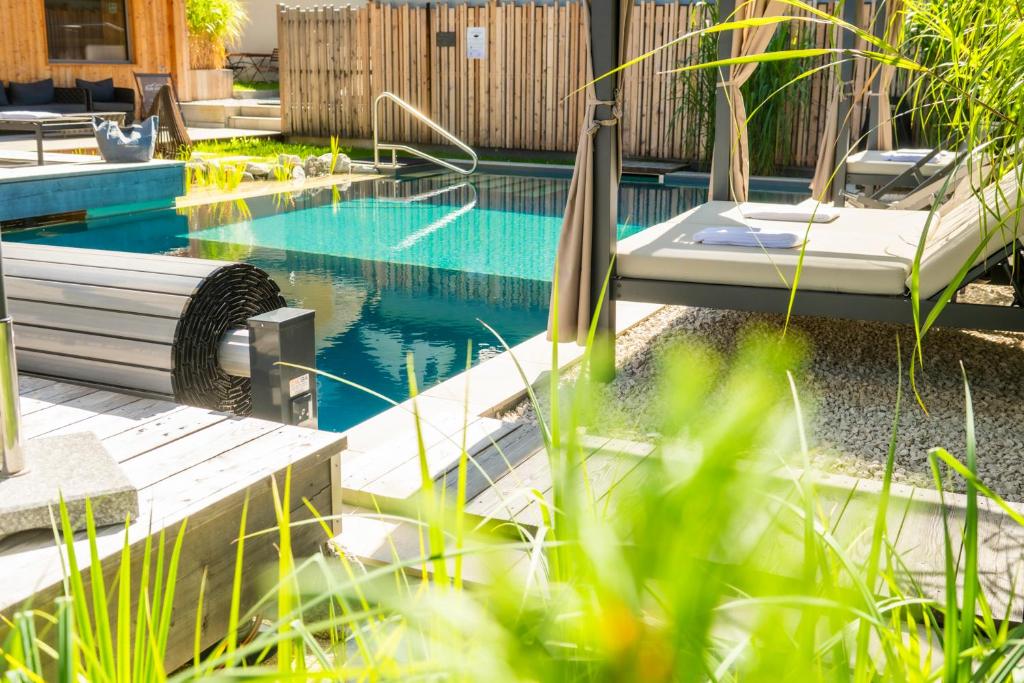 a swimming pool in a backyard with plants at AlpinSpa zur Post Apartment - Bergbahn im Sommer 2026 inklusive in Bad Gastein
