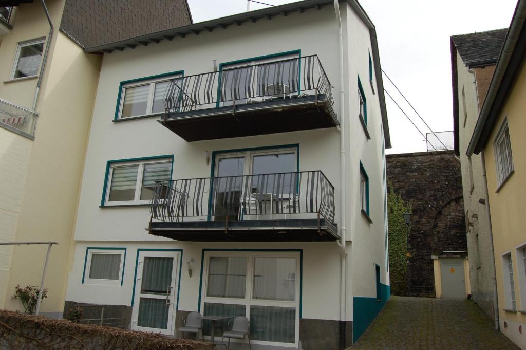 a white building with balconies and tables on it at Ferienhaus Mosel Bub in Bruttig-Fankel