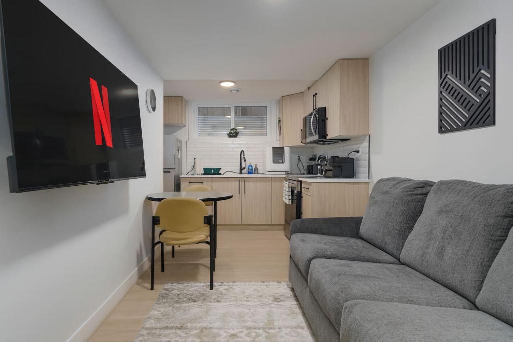 a living room with a couch and a table and a kitchen at Modern Suite by Hospital 2 Near Transit, Wi-Fi, Netflix in Edmonton