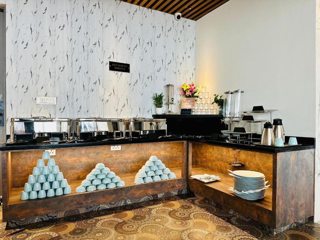 a kitchen with a counter with dishes on it at Hotel Ritvis Elite in Bengaluru