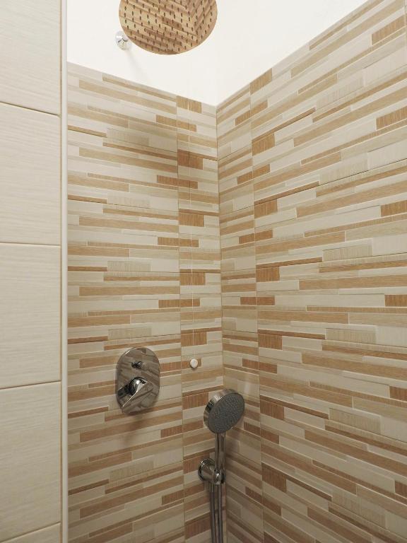 a shower stall with a wooden tile wall at Albergo Annabella in Santa Margherita Ligure