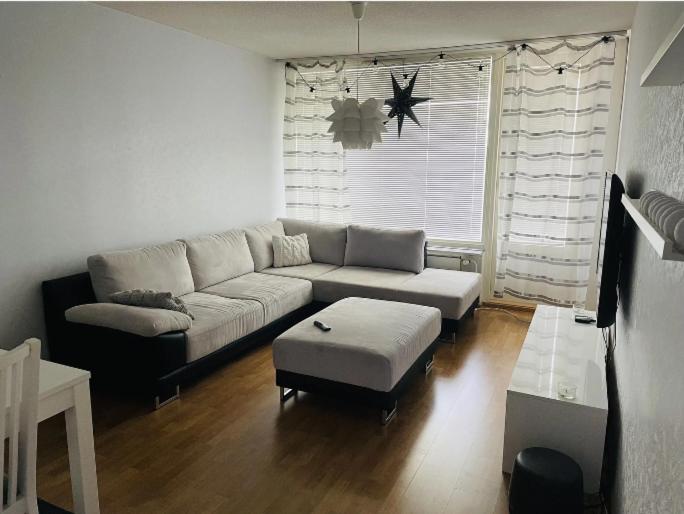 Una sala de estar con un sofá y una mesa de café. en Kotimaailma - High-quality furnished apartment, en Seinäjoki