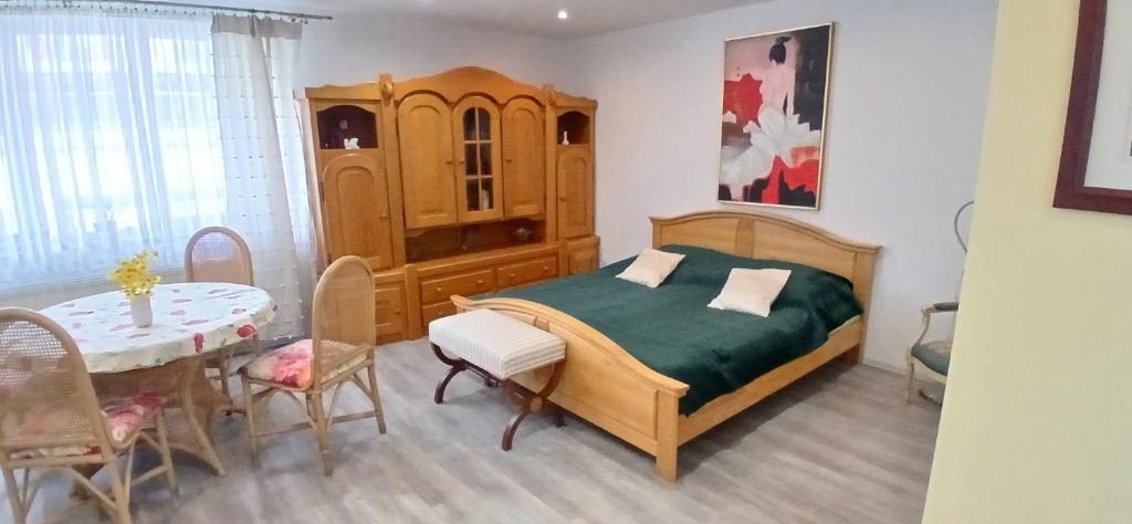 a bedroom with a bed and a table and a dining room at Cichy Zaułek 5A in Brodnica