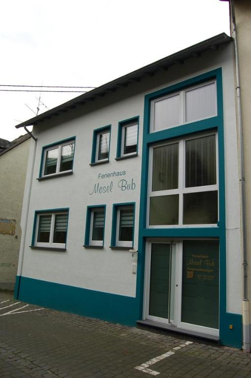 ein weißes und blaues Gebäude mit einer Tür in der Unterkunft Ferienhaus Mosel Bub in Bruttig-Fankel