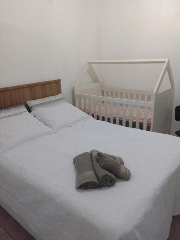a pair of slippers sitting on a white bed at Estúdio em Capão da Canoa in Capão da Canoa