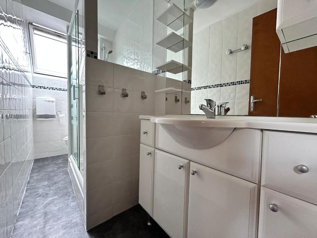 a white bathroom with a sink and a shower at La Petite Rocaille in Soulom